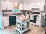 kitchen with refinished white cabinets and an island in the middle 