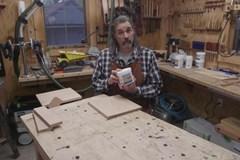 Eric Gorges holding up Aqua Coat grain filler in front of a raw piece of wood